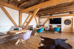 a restaurant with wooden ceilings and wooden tables and chairs at Gästehaus Djuren in Roggenstede