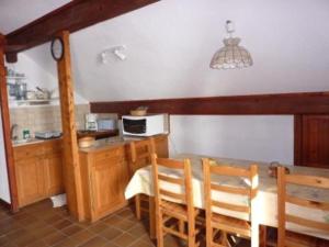 a kitchen with a table and chairs and a microwave at Magnimon 2 - Appartement rustique dans belle maison de village - Domaine Alpe d'Huez in Villard-Reculas