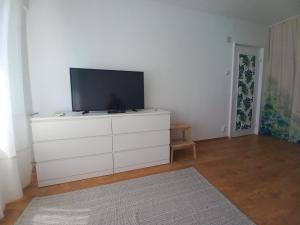 - un salon avec une télévision sur une commode blanche dans l'établissement Garsoniera Comfort, à Bucarest