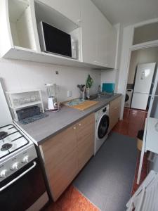 une cuisine équipée d'une cuisinière et d'un lave-linge et sèche-linge dans l'établissement Garsoniera Comfort, à Bucarest 4 autres photos
