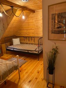 a bed in a room with a wooden ceiling at Domek Serce Lasu in Hutki