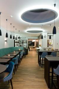 a restaurant with long tables and blue chairs at Hôtel d'Orléans in Orléans