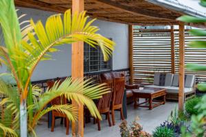 d'une terrasse avec des chaises, une table et un canapé. dans l'établissement Judith Home FIKA CAFE, à Kigali