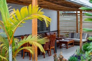 a patio with chairs and a table and a couch at Judith Home FIKA CAFE in Kigali