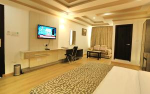 a hotel room with a bed and a flat screen tv at Crown Plaza Residency in Srinagar