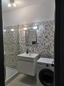 een badkamer met wastafel en wasmachine bij Apartament Giulia by Sea View Luxury Residence in Mamaia Nord – Năvodari +56 foto's