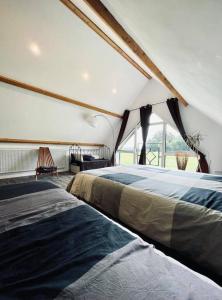 2 camas en una habitación con ventana grande en Le Boulay, en Guichen
