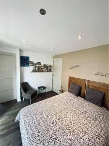 a bedroom with a large bed and a chair at Le Boulay in Guichen +9 photos