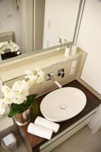 a bathroom with a sink and a mirror and white flowers at Antike & Modern DELUXE in Günzburg
