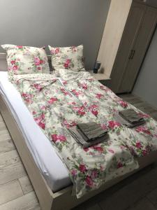 a bed with a white blanket with flowers on it at Apartament Telkom 2 in Milówka