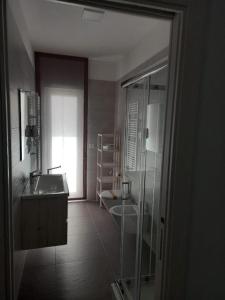 bagno con doccia in vetro e lavandino di Casa MIMI a Matera