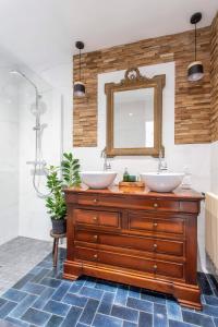 La salle de bains est pourvue de 2 lavabos et d'un miroir. dans l'établissement La Bellevue Bréville - B&B, à Bréville-sur-Mer