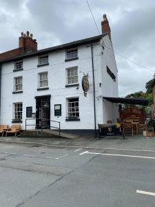 a white building on the side of a street at Old New Inn, Llanfyllin in Llanfyllin