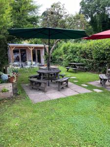 einen Picknicktisch mit einem Regenschirm im Gras in der Unterkunft Old New Inn, Llanfyllin in Llanfyllin