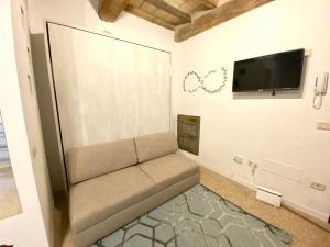 un soggiorno con divano e TV a schermo piatto di Little House a Parma