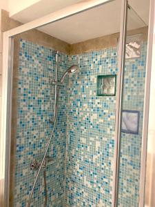 a bathroom with a shower with blue tiles at Little House in Parma