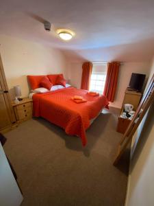 a bedroom with a bed with an orange bedspread at Old New Inn, Llanfyllin in Llanfyllin