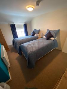 a bedroom with two beds and a tv in it at Old New Inn, Llanfyllin in Llanfyllin