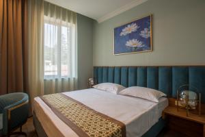 a bedroom with a large bed and a window at Grand Opera Hotel in Kutaisi