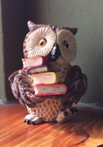 a statue of an owl holding a stack of books at Oeroeboeroe in Roderesch