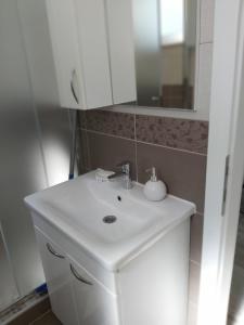 a bathroom with a white sink and a mirror at Apartman Alma in Bihać