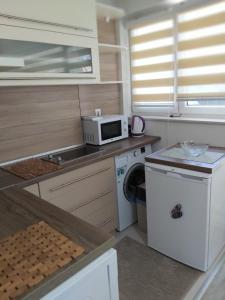 a small kitchen with a sink and a microwave at Apartman Alma in Bihać