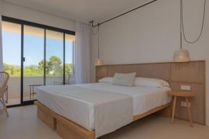 a bedroom with a large bed and a balcony at Hotel Serawa Moraira in Moraira
