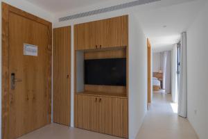 Hotel Serawa Moraira في مورايرا: غرفة معيشة مع تلفزيون بشاشة مسطحة على جدار