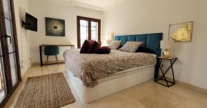 a bedroom with a bed with a blue headboard at Beach and Golf Resort La Perla Miguel Adults Only in Marbella