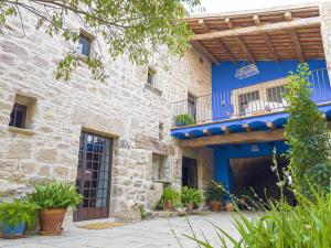 una casa de piedra con fachada azul en Masia de Queralt Luxury Casa Rural Spa y Vistas, en Concabella