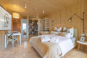 a bedroom with a large white bed and a table at Balthasar Volcano Apartments - Adults only in St. Wolfgang