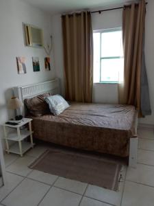 um pequeno quarto com uma cama e uma janela em Residencial Marina Club em São Pedro da Aldeia