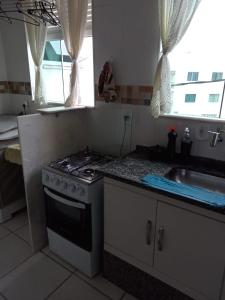 uma cozinha com um fogão e um lavatório em Residencial Marina Club em São Pedro da Aldeia