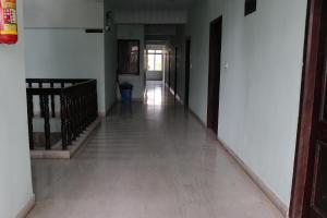 pusty korytarz z białymi ścianami, podłogami i drzwiami w obiekcie Hotel Pearls w mieście Selam