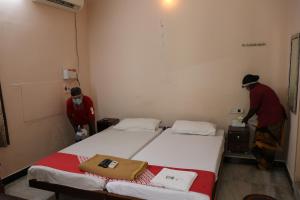 dwoje osób w maskach w pokoju z dwoma łóżkami w obiekcie Hotel Pearls w mieście Selam