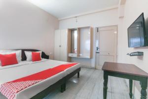 a bedroom with a bed with red pillows and a table at Hotel Pearls in Salem