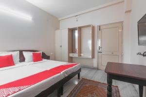 a bedroom with a bed with red pillows and a desk at Hotel Pearls in Salem