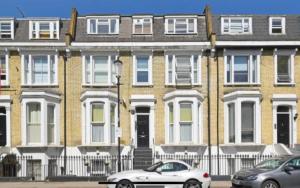 two cars parked in front of a large brick building at Bright 1 Bedroom Central London in London