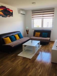 a living room with two couches and a coffee table at Apartman Tami in Doboj