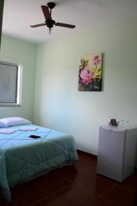 1 dormitorio con 1 cama y una pintura en la pared en Hotel JM Ferreira, en Caeté