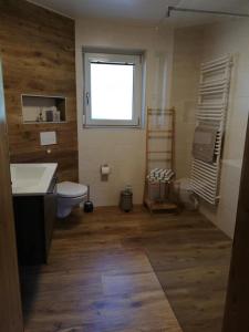 ein Bad mit einem WC, einem Waschbecken und einem Fenster in der Unterkunft Ferienwohnung Pusarnitz in Pusarnitz