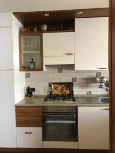 cocina con armarios blancos y fogones en CasAnna nel cuore del Salento Arnesano LE, en Arnesano