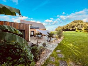 a house with a patio and a grass yard at Le Boulay in Guichen