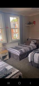 1 dormitorio con 2 camas y ventana en Caversham Lodge en Reading