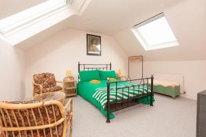a attic bedroom with a bed and a chair at Funky flat in Margate's Westbrook Bay in Kent