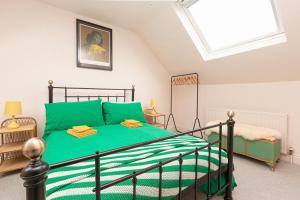 a bedroom with a green bed and a window at Funky flat in Margate's Westbrook Bay in Kent
