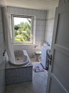 Ferienhaus Jagomast في Glindow: حمام مع حوض استحمام ونافذة