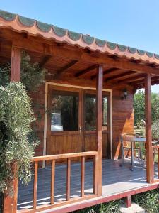 una terraza de madera con una puerta de madera y una mesa en olive garden bungalow, en Fethiye