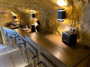 a kitchen with a counter with a microwave on it at Le Tunnel du Moulin in Noyers-sur-Cher