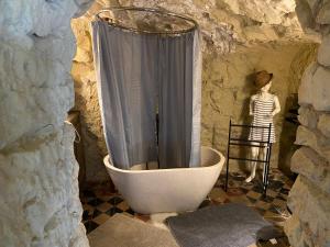 a shower in a bathroom with a woman standing next to it at Le Tunnel du Moulin in Noyers-sur-Cher +9 photos